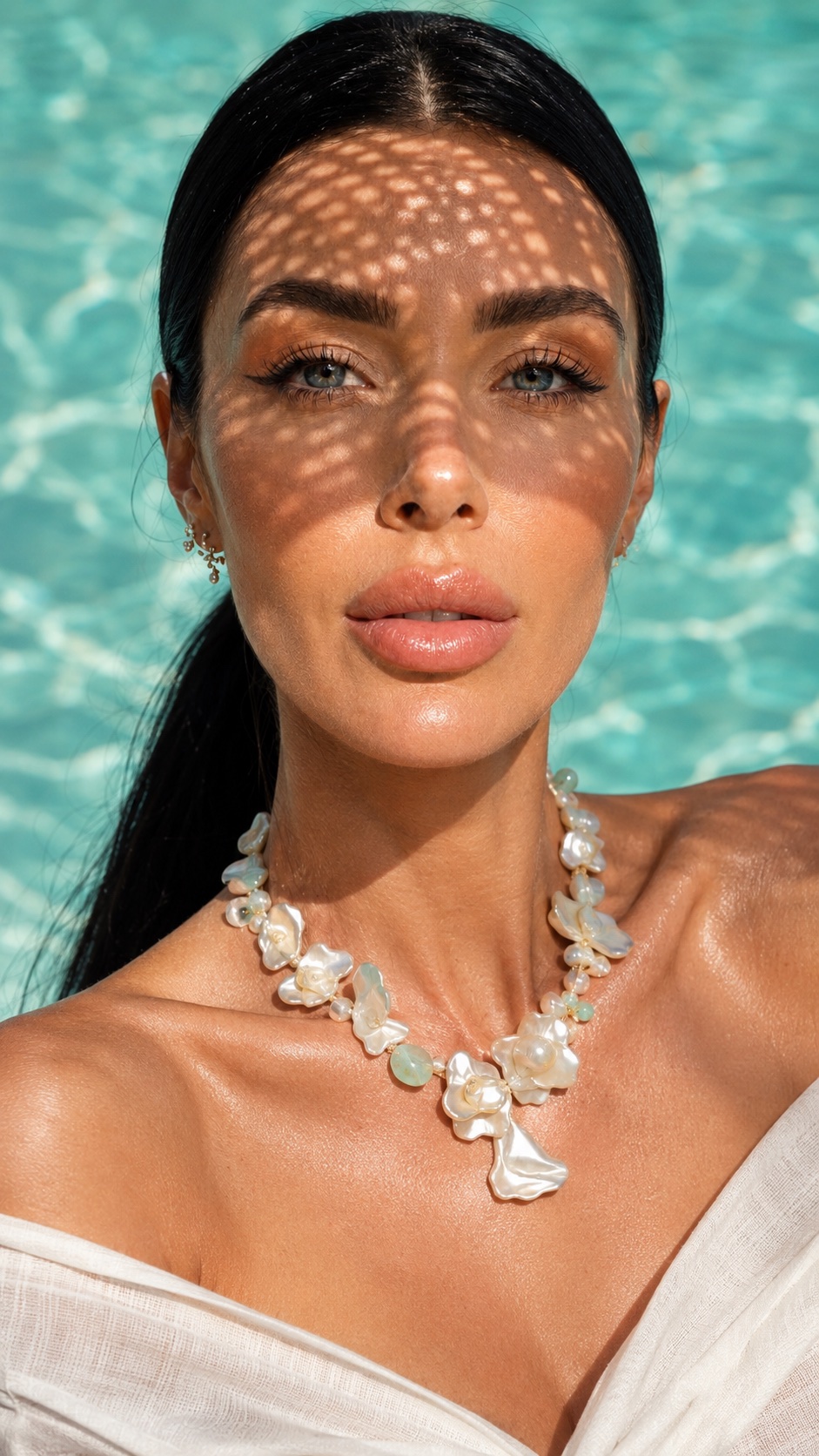 Pearl necklace portrait beside a turquoise pool